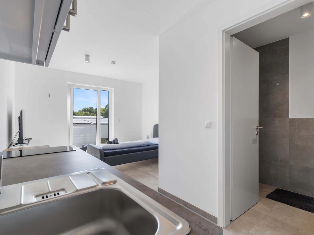 Blick von der Küche ins Wohnzimmer und Badezimmer mit offenen Türen
