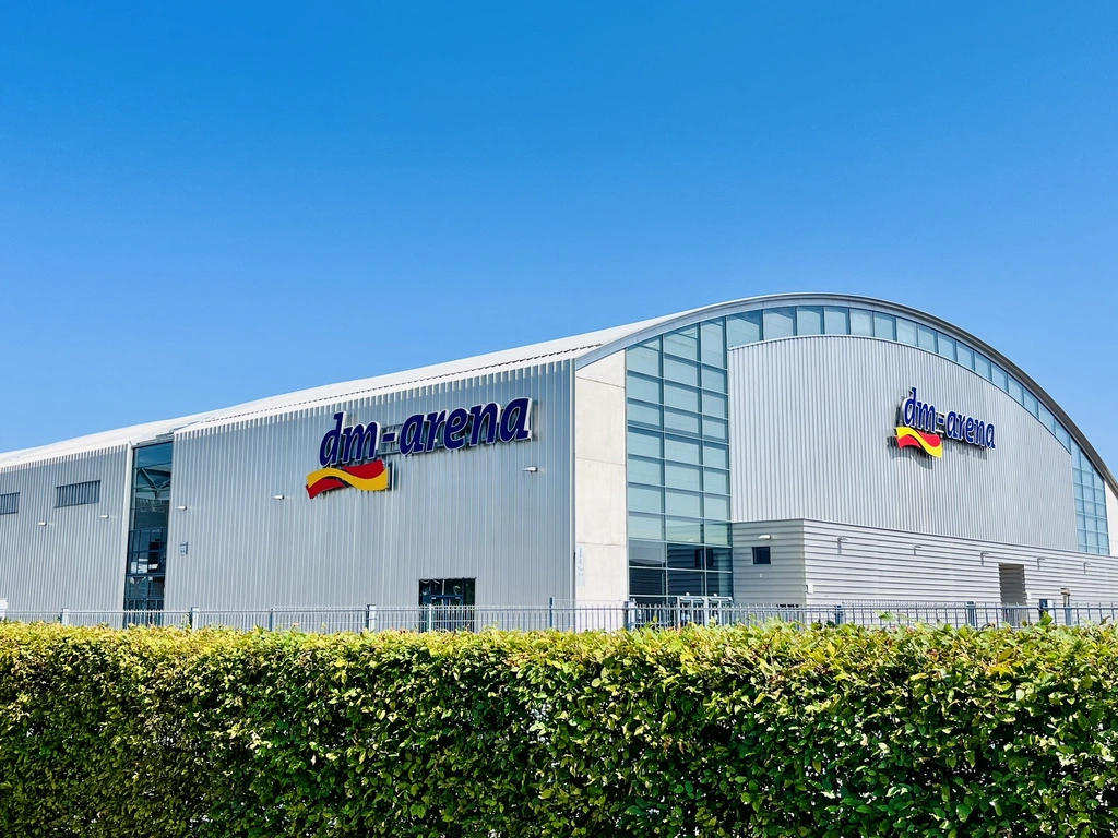 Gebäude der dm-arena unter klarem blauem Himmel