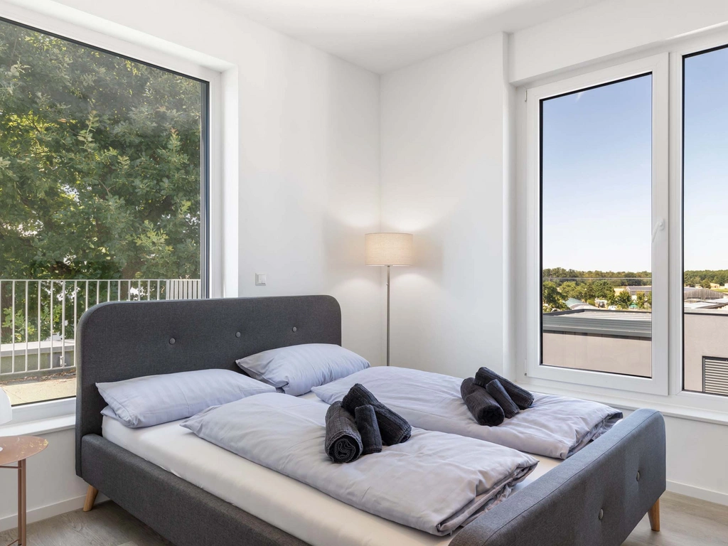 Modernes Schlafzimmer mit großem Fenster und Blick ins Grüne