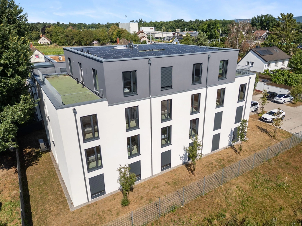 Modernes Mehrfamilienhaus mit Solaranlage in grüner Wohngegend