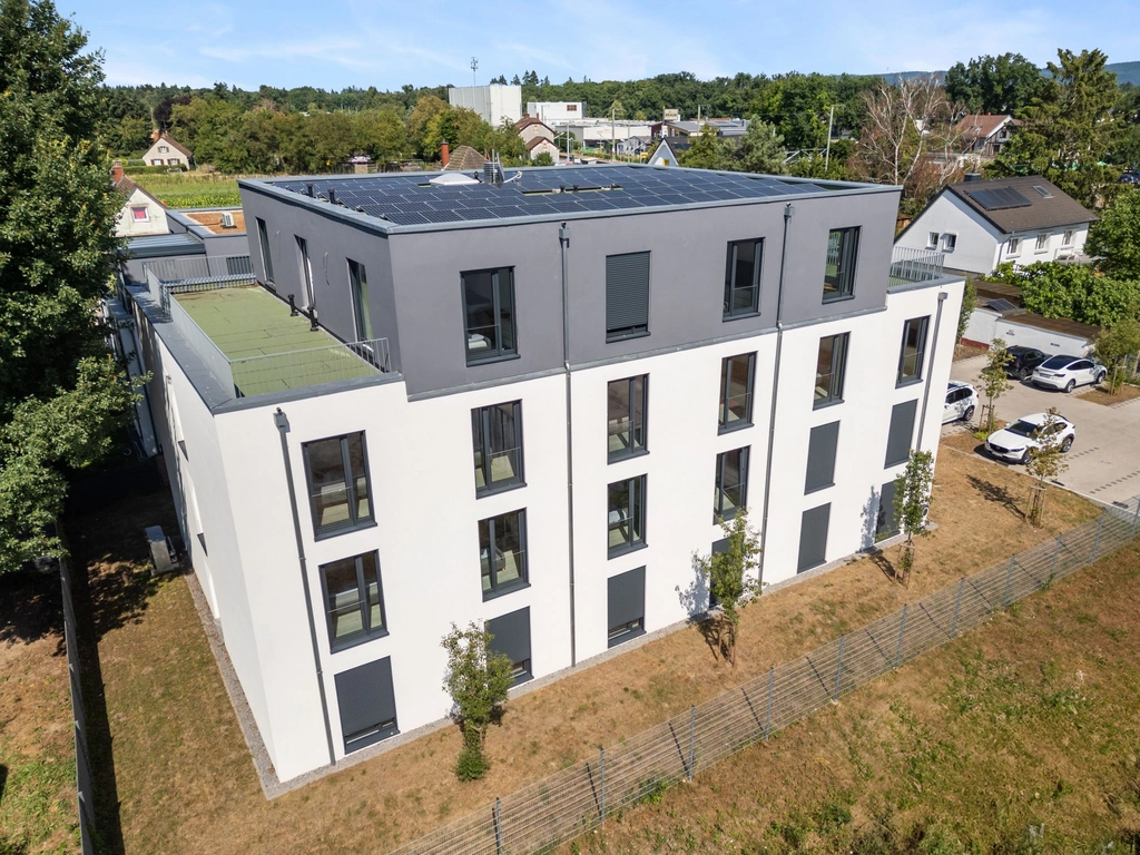 Modern apartment building with solar panels in a green residential area