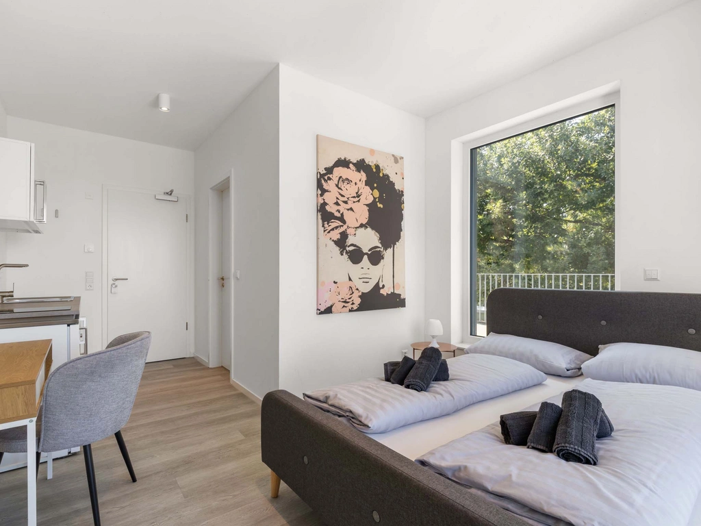 Minimalistisches, modernes Schlafzimmer mit Kunst, großem Fenster und Holzboden
