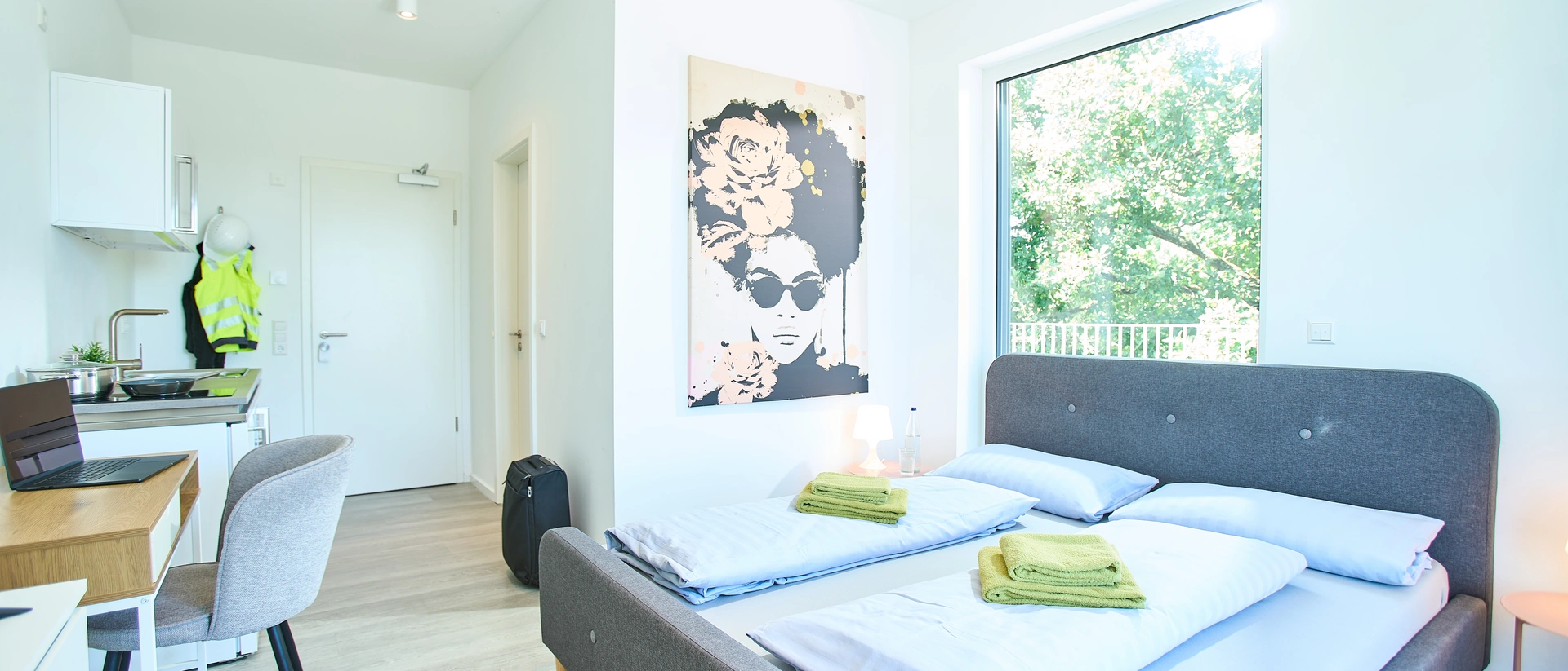 Helles Zimmer mit Doppelbett, Küchenzeile, Esstisch und großem Fenster